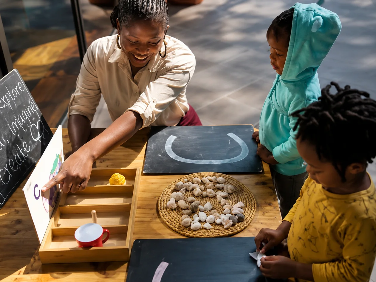 A teacher exploring shells and loose parts with children at The Little Nest, Arusha